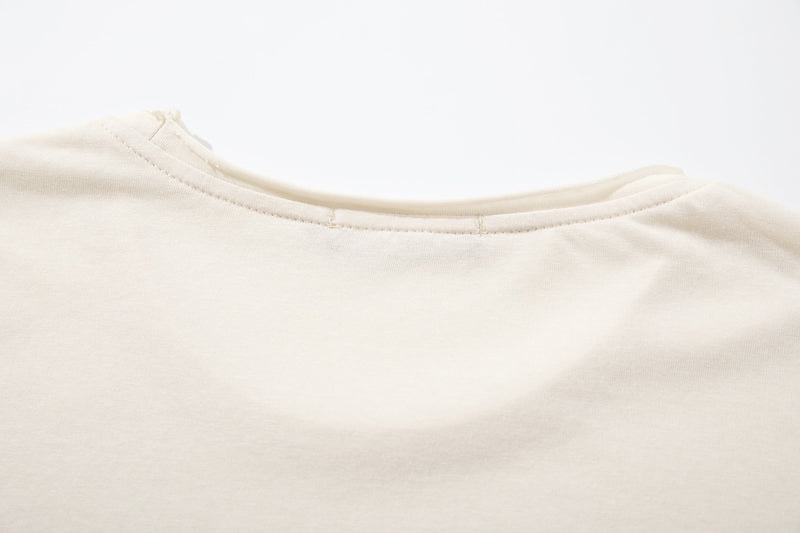 Close-up of upper back neckline seam on cream long sleeve tee