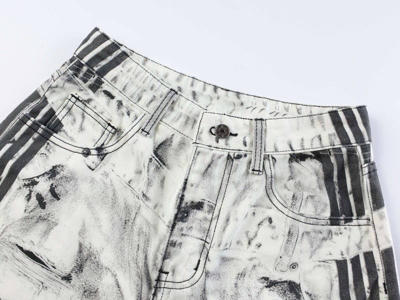 Close-up of front waistband on striped ripped denim jeans with button closure and belt loops