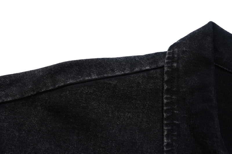 Close-up of a black washed polo shirt with a faded vintage texture and visible collar detail