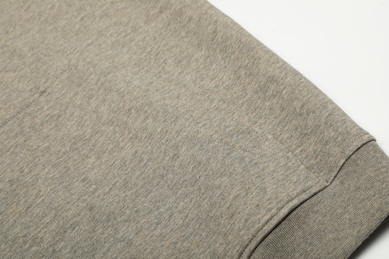 Close-up of beige hoodie fabric showing the sleeve and shoulder seam texture