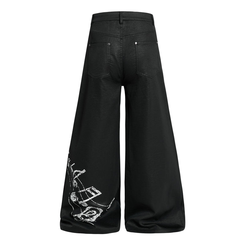 Back view of black wide-leg pants with back pockets and graphic print on one leg hem