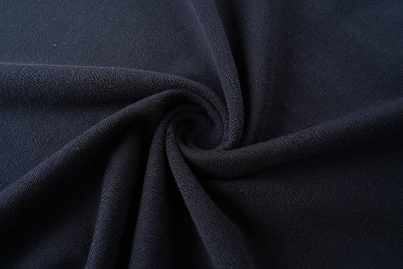 Close-up of dark navy faded cotton T-shirt fabric with soft folded texture