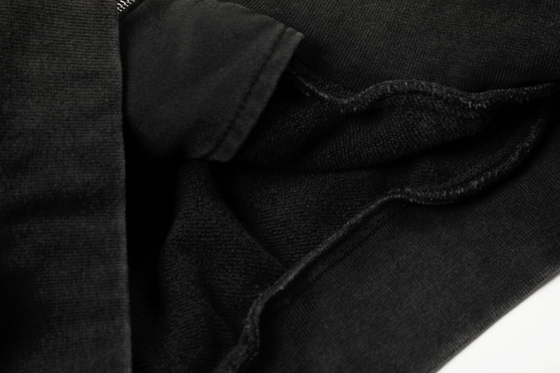 Close-up of black hoodie pocket lining and ribbed cuff