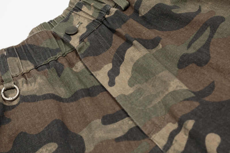 Close-up of waistband ring and snap button on green brown camo shorts