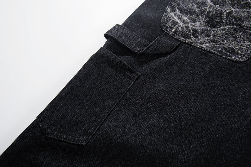 Close-up of black denim cargo pocket flap and cracked panel yoke detail