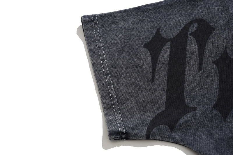 Close-up of a vintage washed dark gray gothic graphic T-shirt sleeve with bold black print and contrast stitching