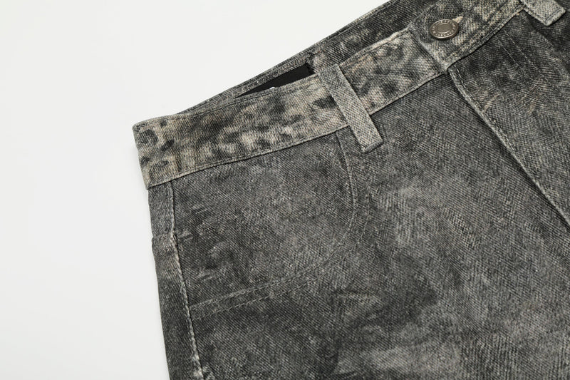 Close-up of left front pocket and waistband on gray washed denim pants