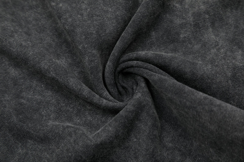 Close-up of dark washed cotton T-shirt fabric with soft, textured knit and subtle faded finish