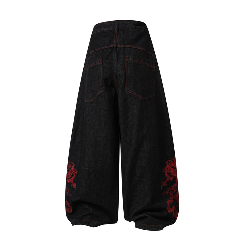 Back view of black wide-leg denim pants with red dragon embroidery near the hems