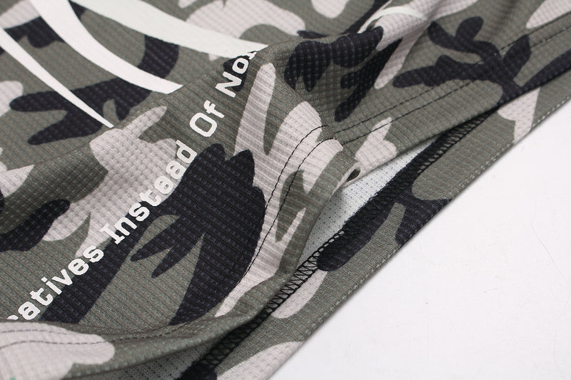 Close-up of sleeve hem and side seam with printed text on camo waffle fabric