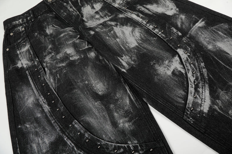Close-up of black painted jeans legs with curved seam studs and wide-leg cut