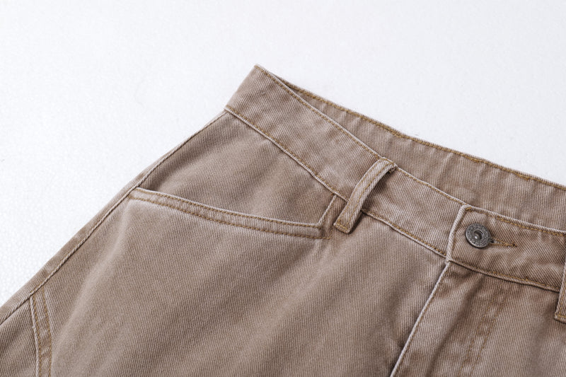 Close-up of brown jeans front waistband and top button