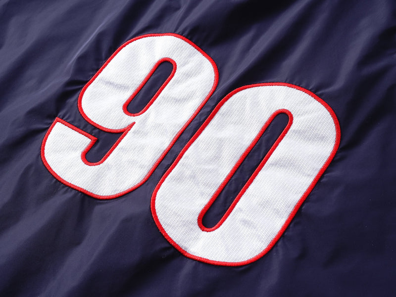 Close-up of large white 90 graphic with red outline on navy nylon pullover