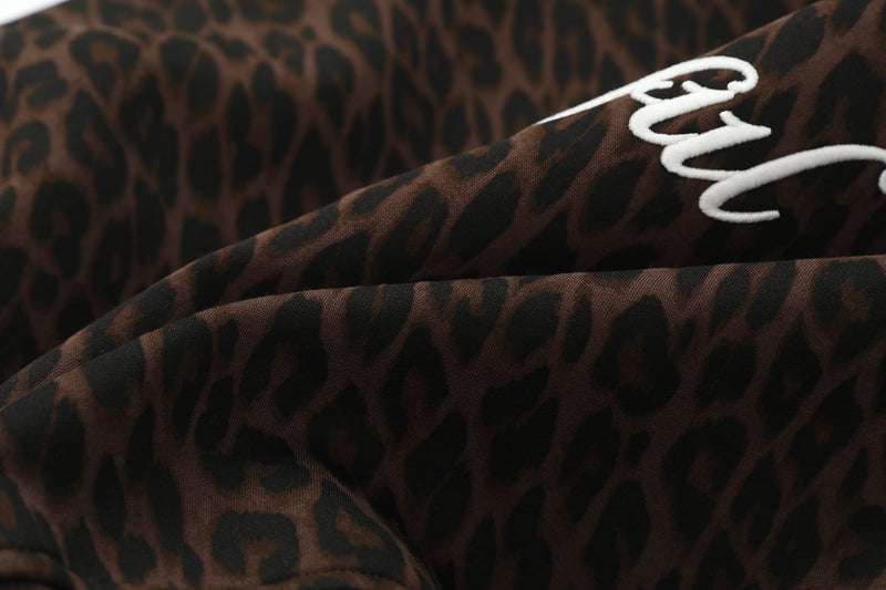Close-up of leopard print hoodie fabric with white script embroidery detail