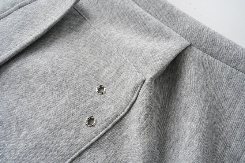 Close-up of back pocket flap with two metal eyelets on gray cargo shorts