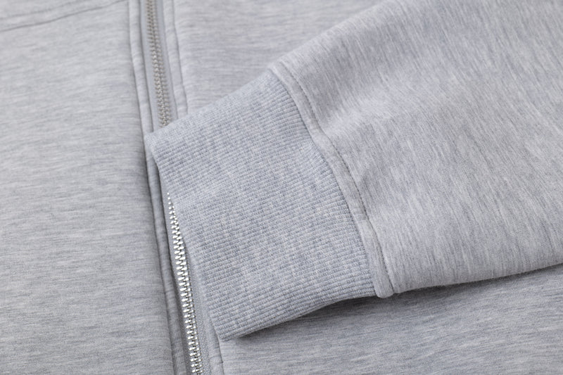 Close-up of light gray hoodie sleeve cuff and front zipper