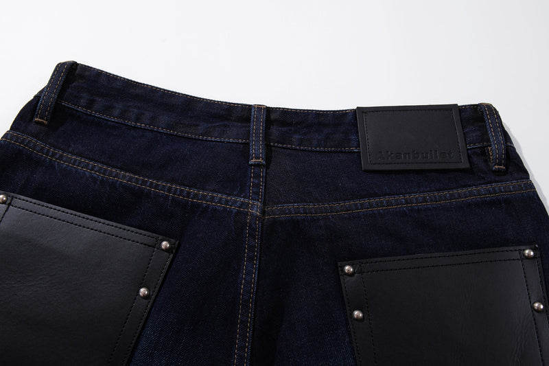 Close-up of the back waistband and leather patch pockets on deep indigo jeans