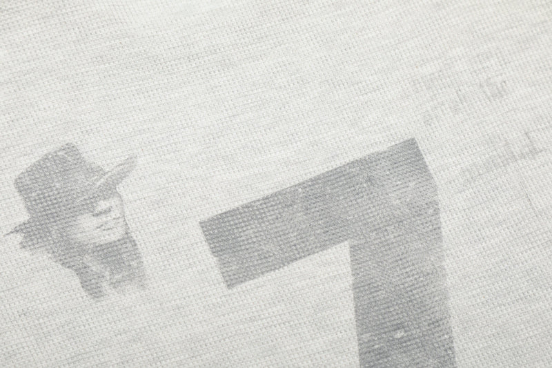 Close-up of light gray waffle knit fabric with faint print details