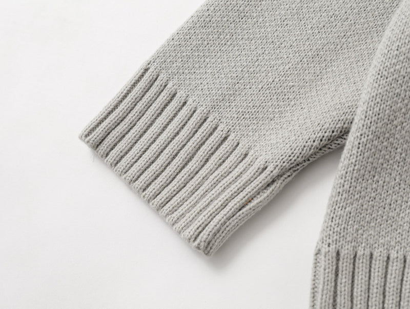 Close-up of light gray ribbed sleeve cuff on the cardigan