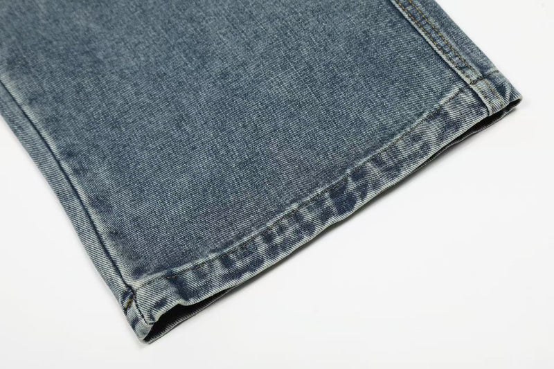 Close-up of hem on faded blue wide-leg denim jeans