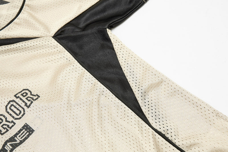 Close-up of a cream mesh sport jersey with black paneling and bold streetwear graphic details
