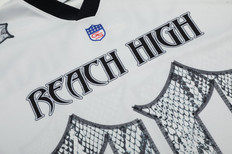 White jersey tee with gothic Reach High lettering and snakeskin pattern details on the front