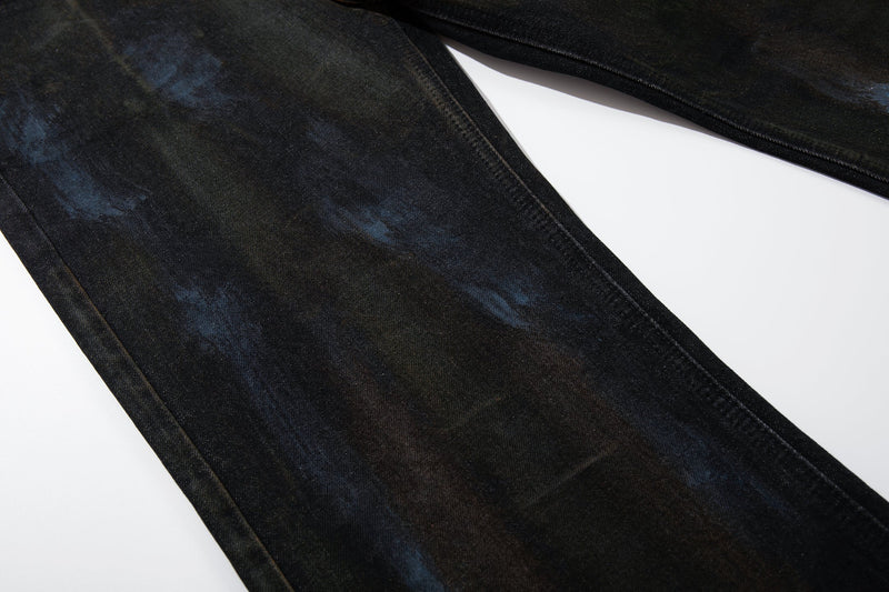 Close-up of the leg fabric showing painted wash details on dark denim