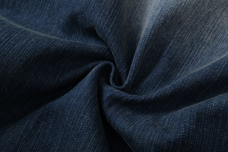 Close-up of dark blue denim fabric texture with soft folds and visible weave