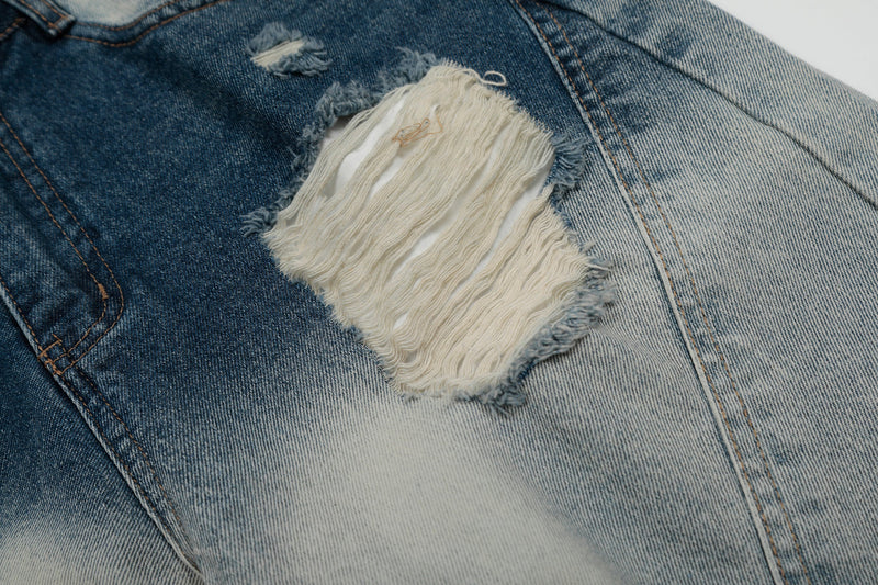 Ripped frayed distress on bleached blue denim shorts with exposed white threads