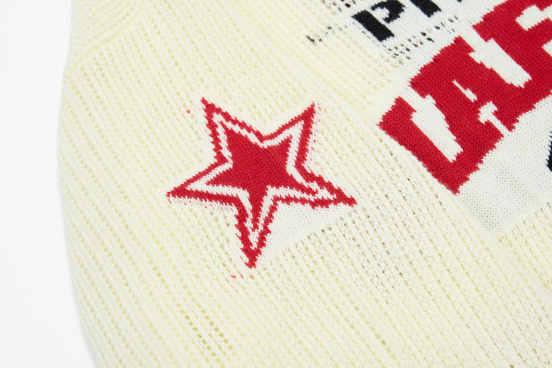 Cream knit polo with red varsity star graphic and collegiate lettering detail