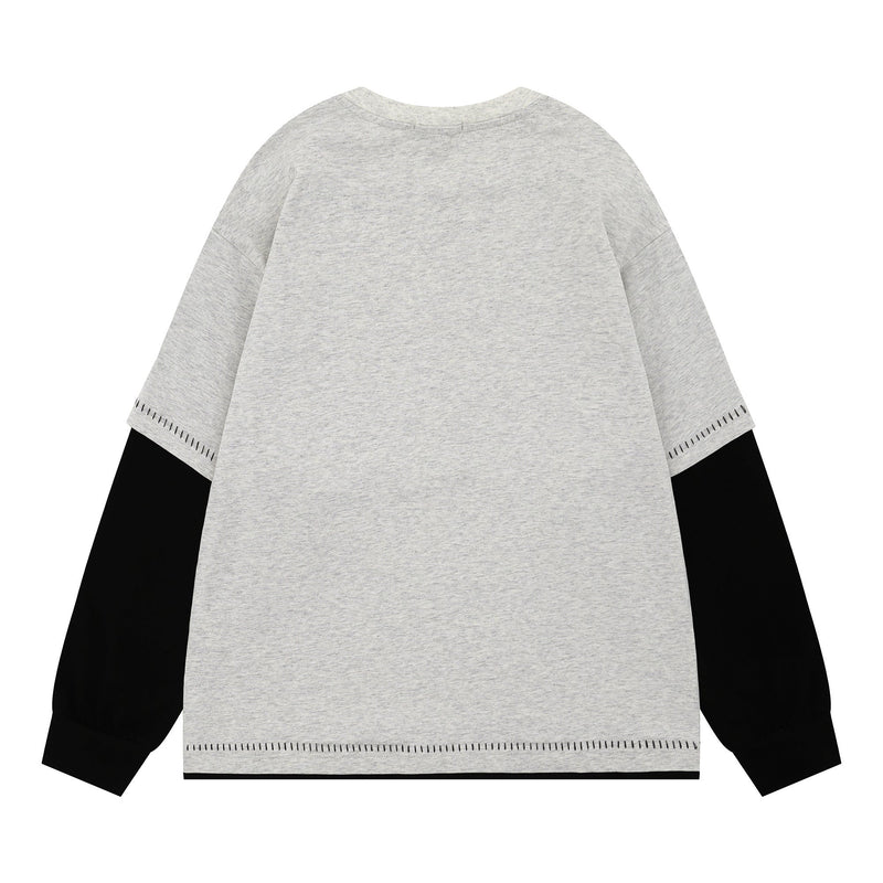 Back view of heather gray long-sleeve tee with black underlayers and contrast stitching