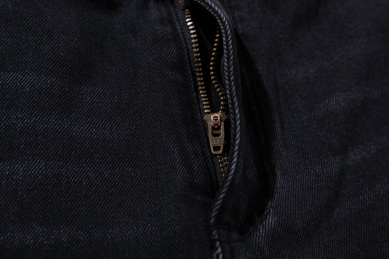 Close-up of the front fly with bronze zipper on washed black denim