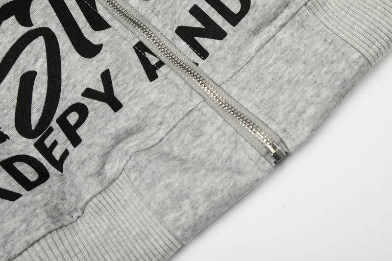 Close-up of light gray hoodie hem and lower zipper with graphic print