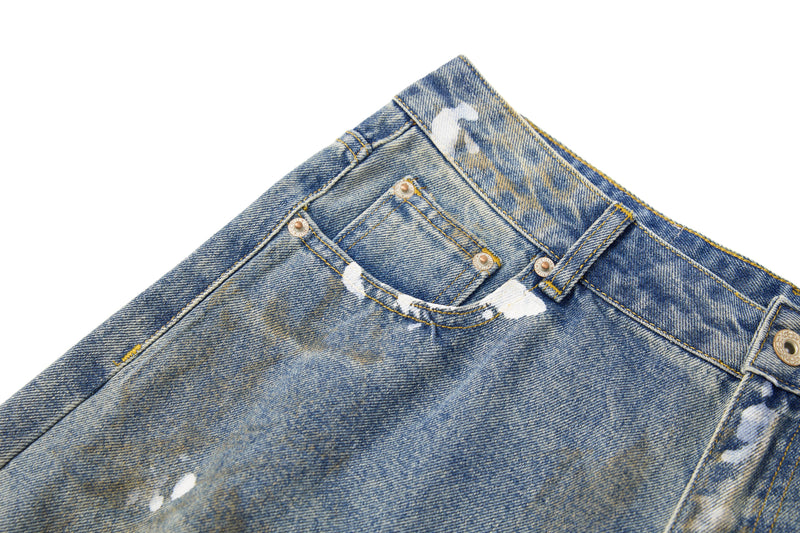 Close-up of front waistband with button closure and pocket stitching on blue jeans