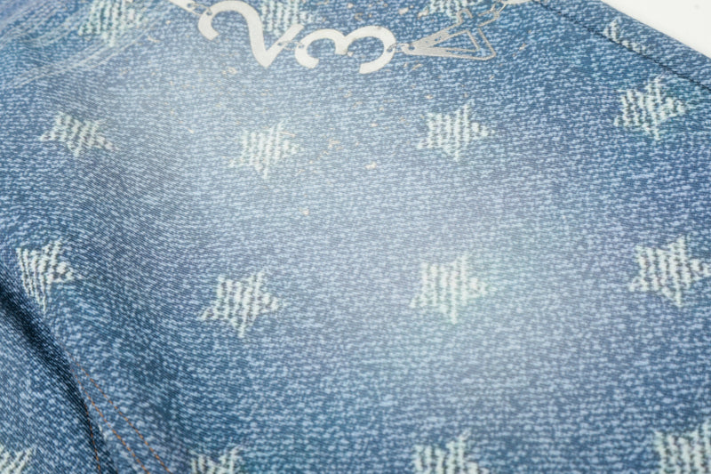 Close-up of blue star-wash denim fabric with white printed markings and faded texture