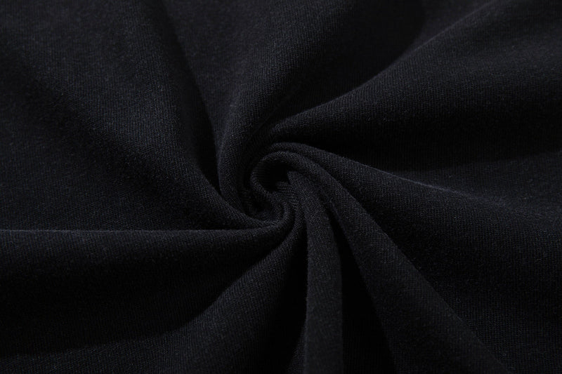 Close-up of black washed cotton tee fabric with soft folds and textured vintage dark finish