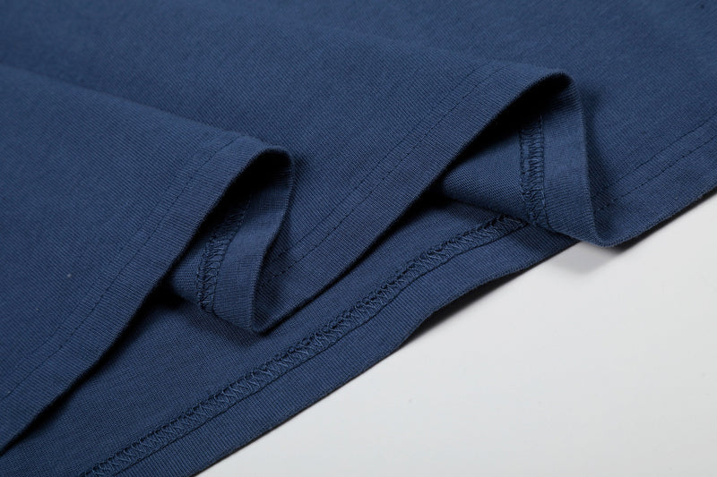 Close-up of navy washed cotton tee hem with reinforced stitching and folded sleeve detail