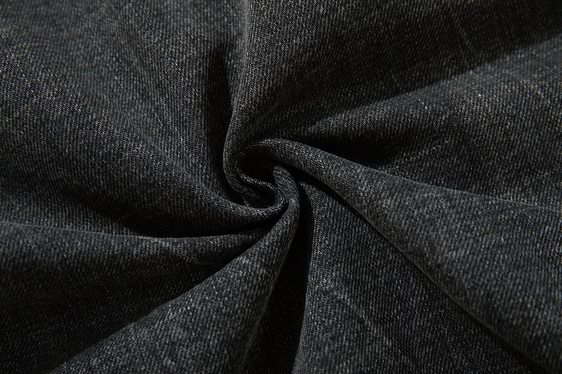 Close-up of dark denim fabric showing the jeans' textured cotton weave