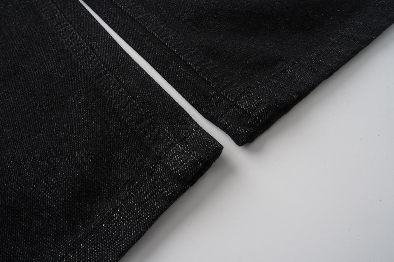 Black denim pant hem close-up with straight wide-leg opening