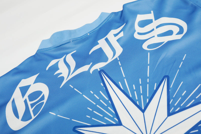 Blue mesh streetwear football jersey with bold white starburst graphics and abstract logo print on the chest