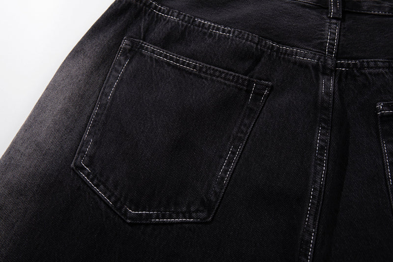 Close-up of the back left pocket on dark wash denim with faded edge detailing