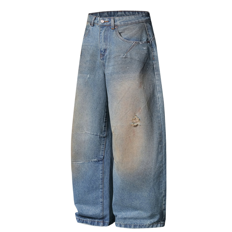 Front angled view of light blue wide-leg jeans with faded distressing and frayed rip