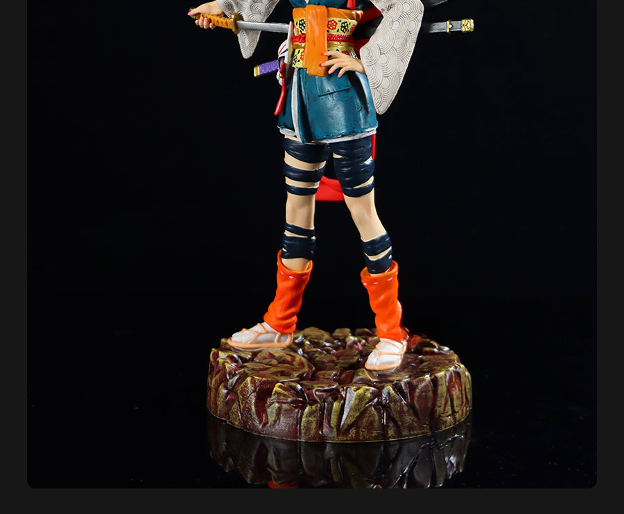 The Seakoff Android 18 Collectible Figure, 26cm, captures a samurai pose with intricate attire on a rocky base, featuring a patterned robe, knee-high orange boots, and blue straps. This Dragon Ball Z figure grips a sword while another rests at the waistband.