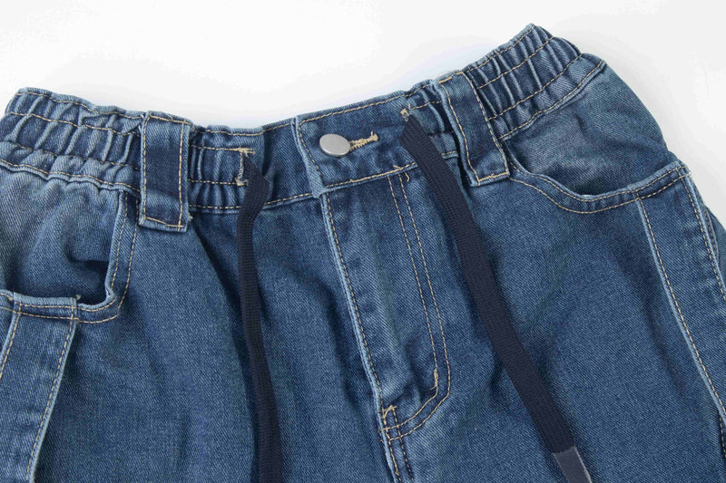 Close-up of blue denim waistband with button, belt loops, and drawstring