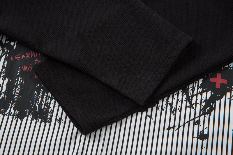 Black ribbed long sleeve layered under striped shirt, close-up of cuff and hem overlap