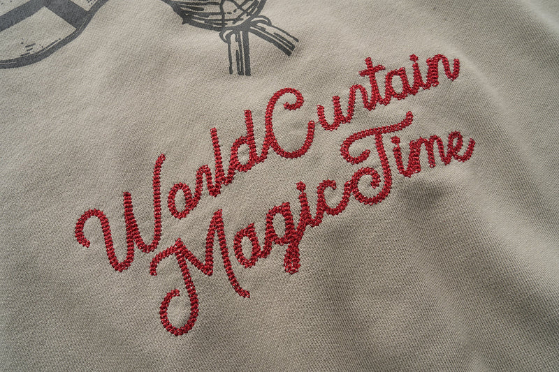 Close-up of red embroidered script text on the back of a taupe hoodie