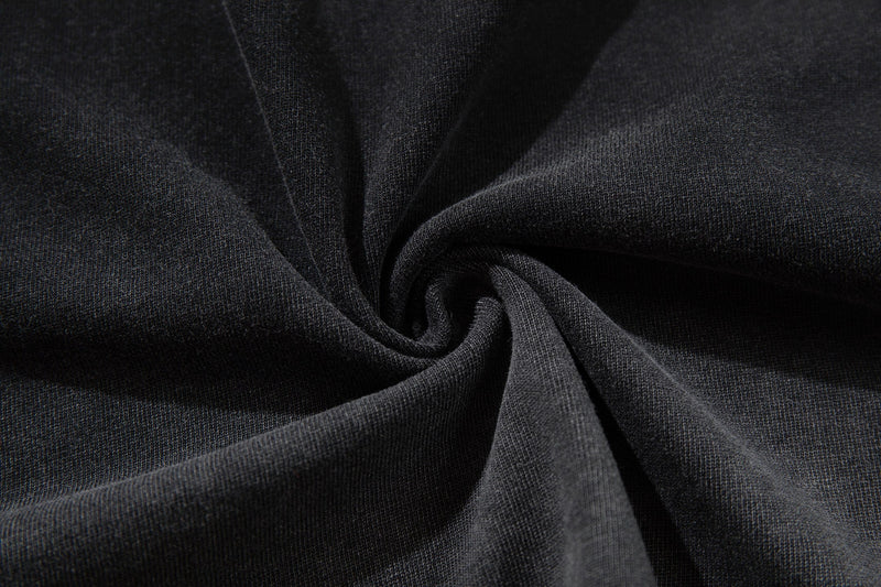 Close-up of black washed vintage cotton tee fabric with soft ribbed texture and draped folds