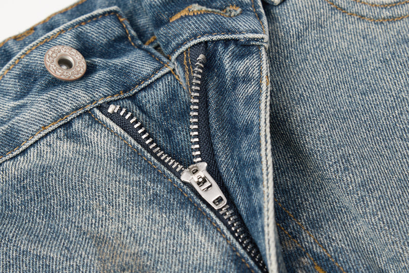 Close-up of zipper fly and button on blue denim jeans