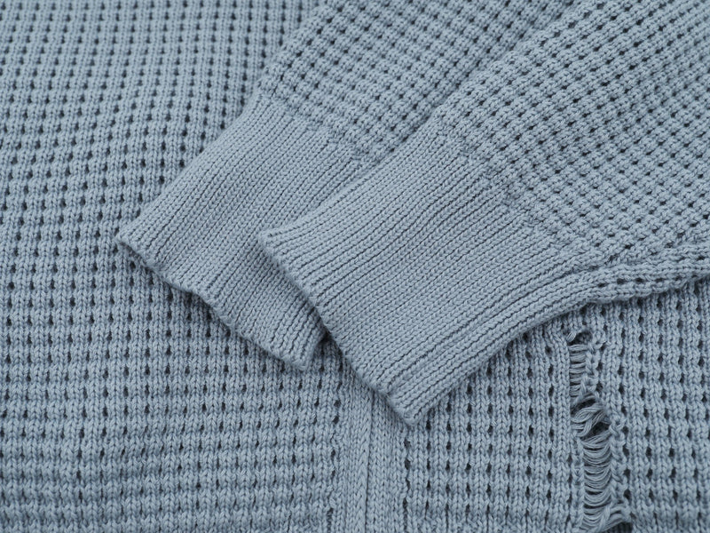 Close-up of light blue cardigan cuff, sleeve, and waffle knit texture