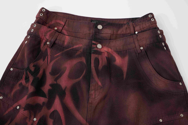 Burgundy and black jorts front view with grommets, studs, and tribal graphic print